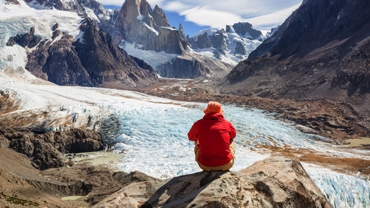 man in red jacket on top of the mountain