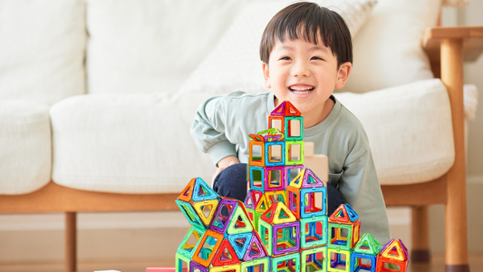 happy bot toddler playing magnetic building blocks