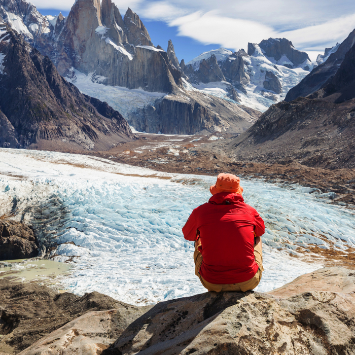 man in red jacket on top of the mountain