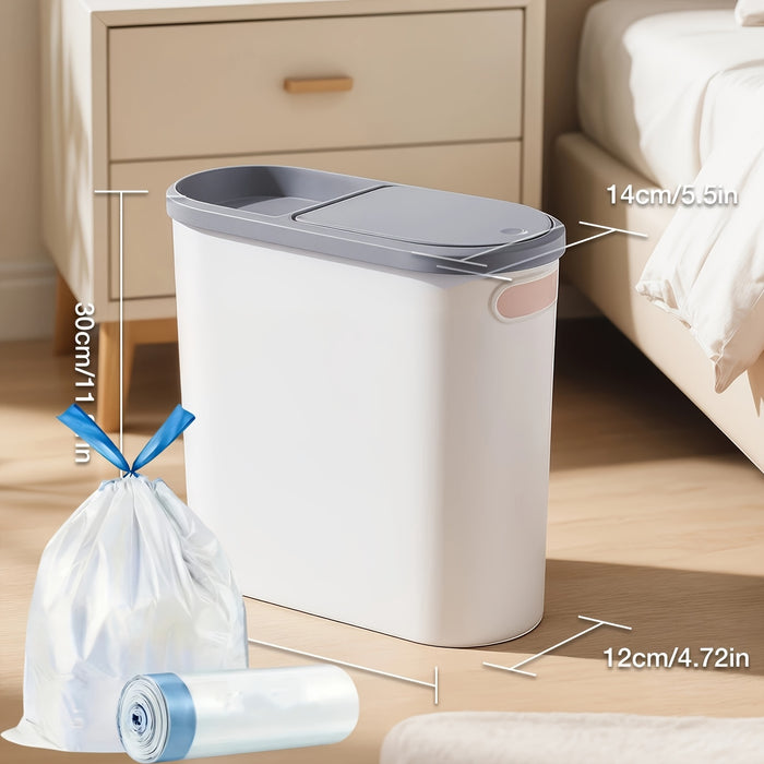 White trash bin with gray lid on a wooden floor, next to a white bag and roll of liner.
