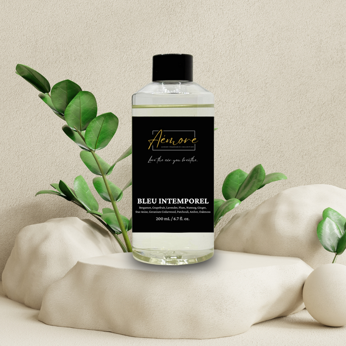 Perfume bottle labeled 'Aémore' with green leaves on a neutral background