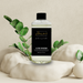 Bottle of 'Luxe Desire' with a black label on a neutral background with decorative elements.