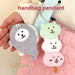 Fish cake and dango plush charms hanging on a pink handbag