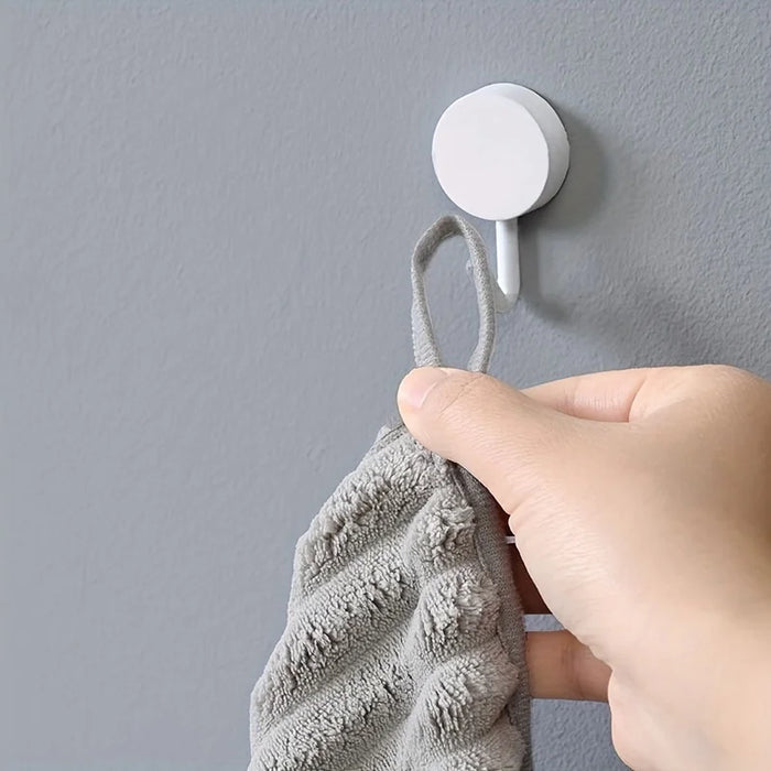 Hand hanging a grey towel by its loop on a hook