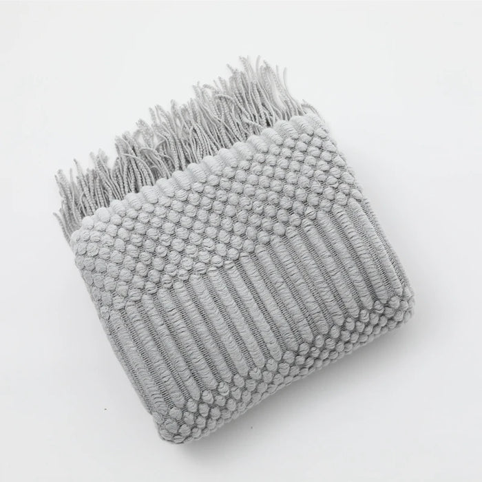 Folded light grey bubble knit throw