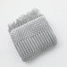 Folded light grey bubble knit throw