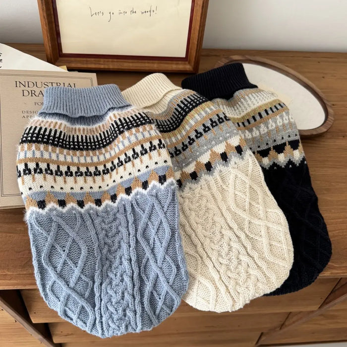 Blue, cream and navy knit dog sweaters laid together