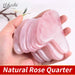 Hand holding a stack of pink heart-shaped gua sha tools
