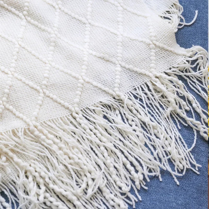 Close-up of cream diamond knit and tassel fringe