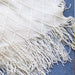 Close-up of cream diamond knit and tassel fringe