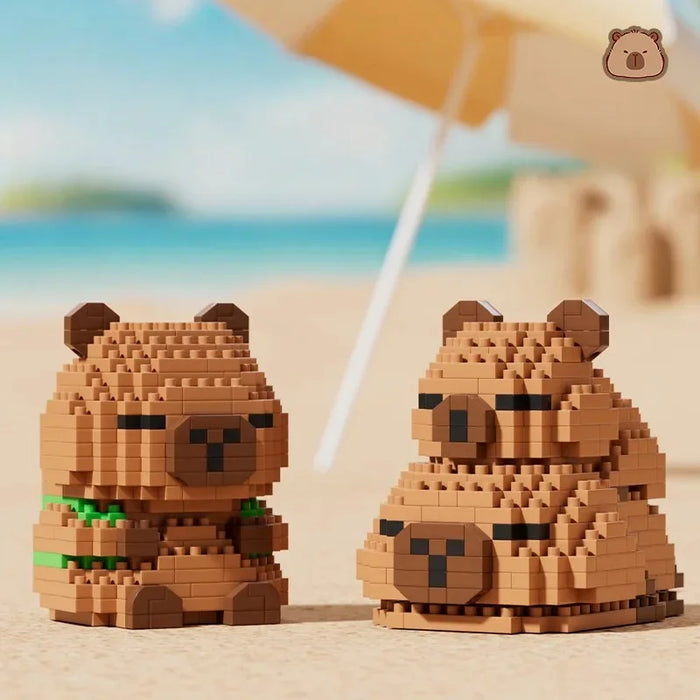 Two capybara figures side by side on a beach