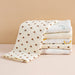 Stack of folded muslin baby blankets, heart print on top