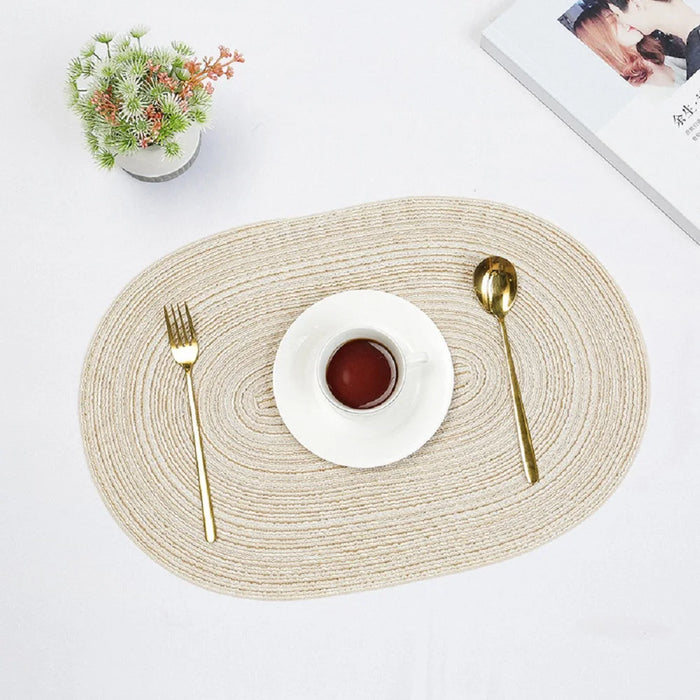Cream oval braided placemat with a cup and cutlery