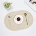 Cream oval braided placemat with a cup and cutlery