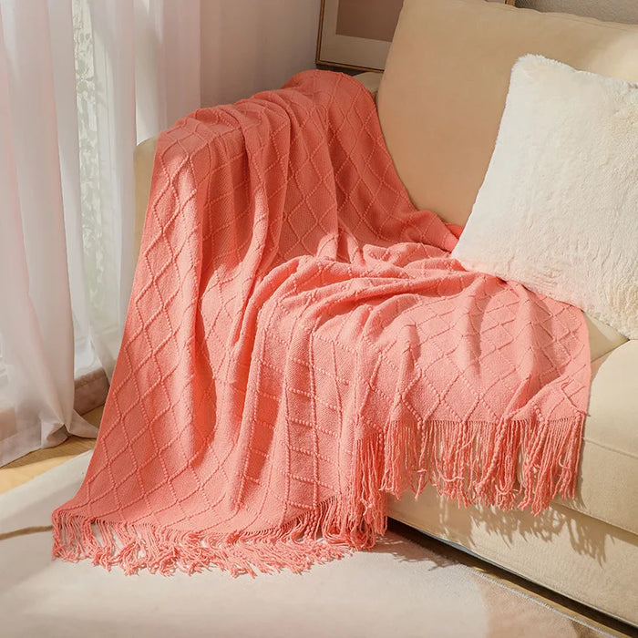 Coral pink diamond knit throw on a cream sofa