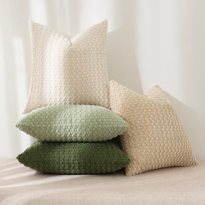 Cream and green textured cushions stacked on a chair