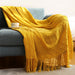 Yellow cable knit throw on a grey sofa