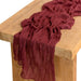 Burgundy gauze table runner on a wooden table