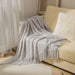 Light grey diamond knit throw on a cream sofa