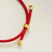 Red cord with a gold sliding bead adjuster