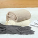 Folded knit throws in khaki, cream and dark grey