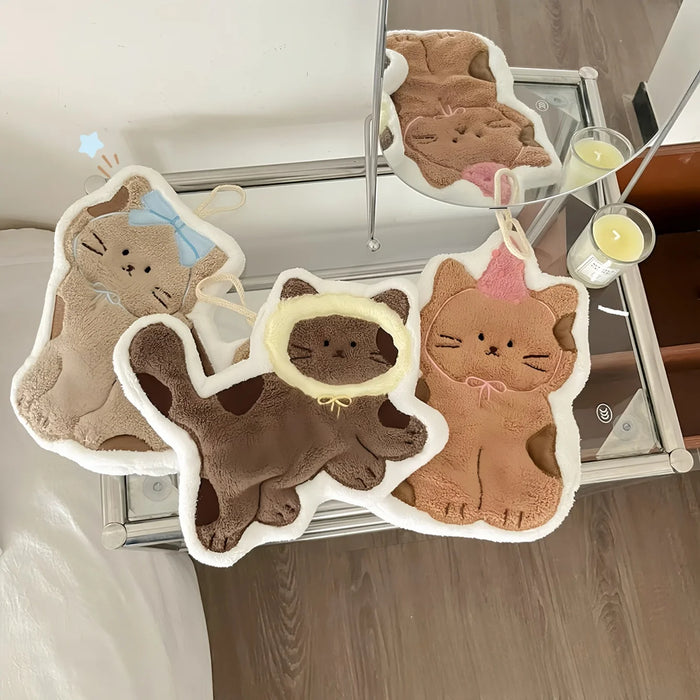 Cat-shaped hand towels hanging by a kitchen window