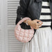 Woman holding a pink mini puffer tote