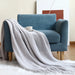 Grey net knit throw on a blue armchair