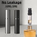 Grey and black perfume atomizers beside a perfume bottle