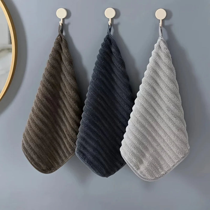 Brown, navy and grey hand towels hanging from hooks