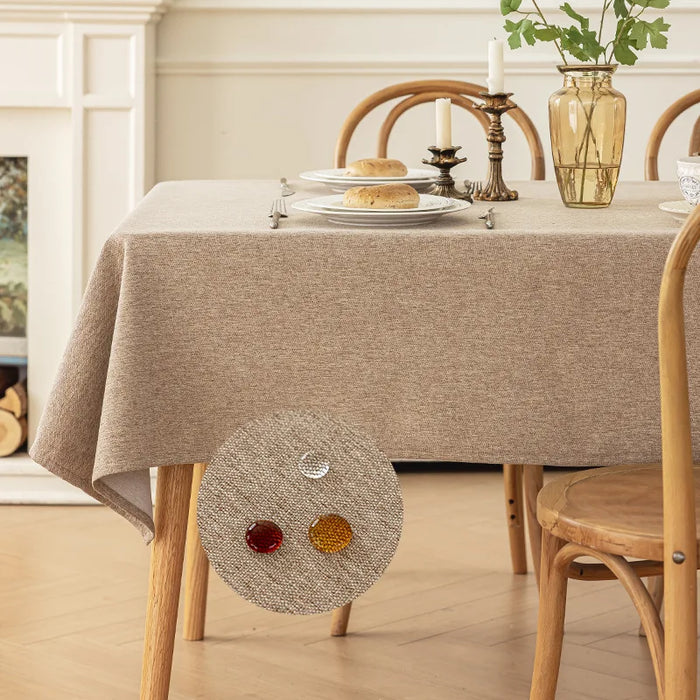 Khaki linen-look tablecloth on a dining table with a spill beading up