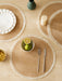 Natural round placemats with fringe on a dining table