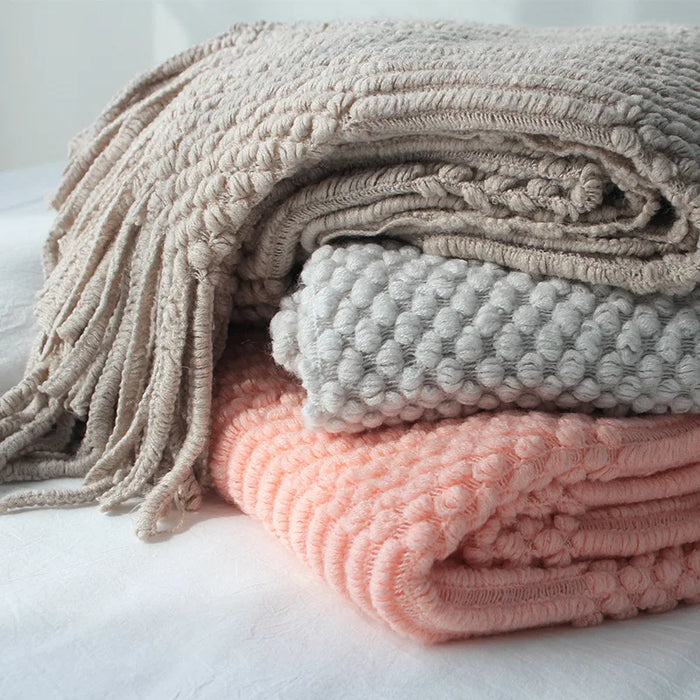 Folded knitted throws in grey, blue and pink