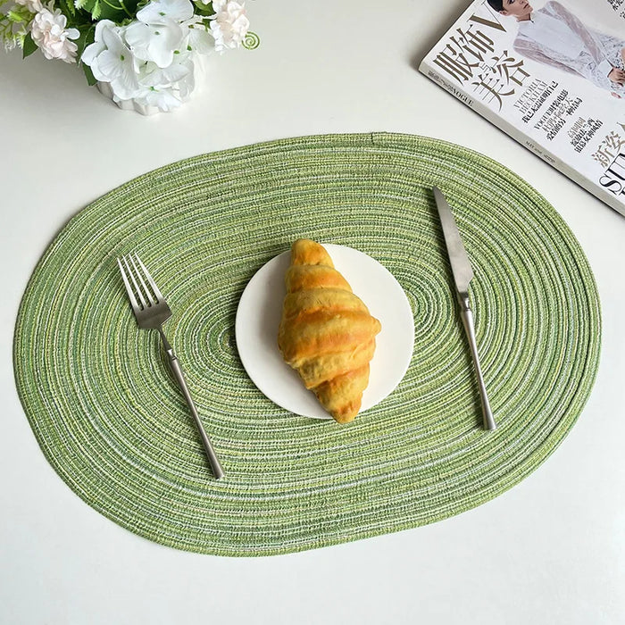 Green oval braided placemat with a croissant
