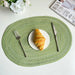 Green oval braided placemat with a croissant