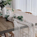 White gauze runner on a wooden table with eucalyptus