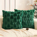 Two green plush Christmas tree cushions on a sofa