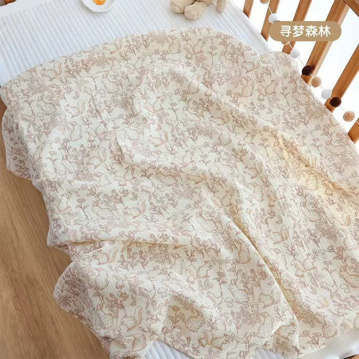 Pink forest print muslin blanket in a crib