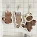 Three cat hand towels on wall hooks above a sink