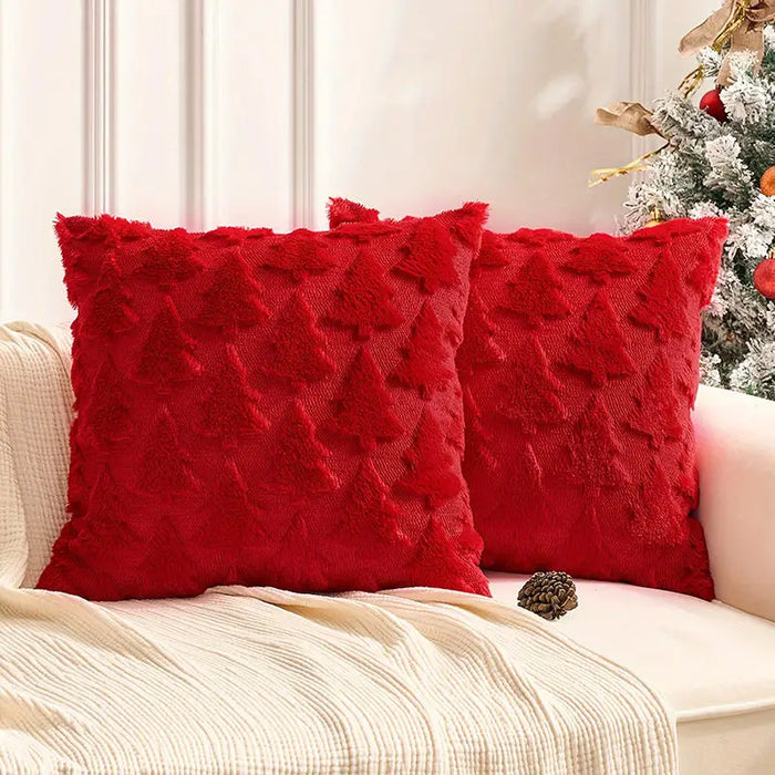 Two red plush Christmas tree cushions on a sofa