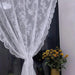 White lace curtain tied back against a dark window