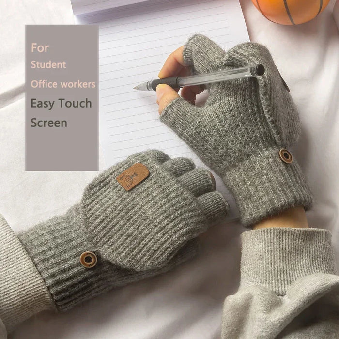 Hand in a light grey fingerless glove writing with a pen