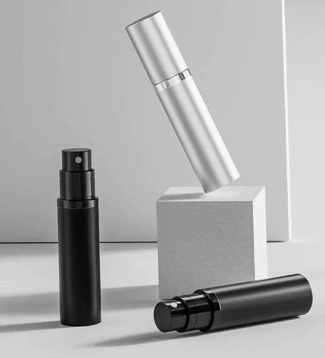 Black and silver perfume atomizers on white blocks