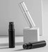 Black and silver perfume atomizers on white blocks