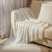 Cream white cable knit throw on a sofa