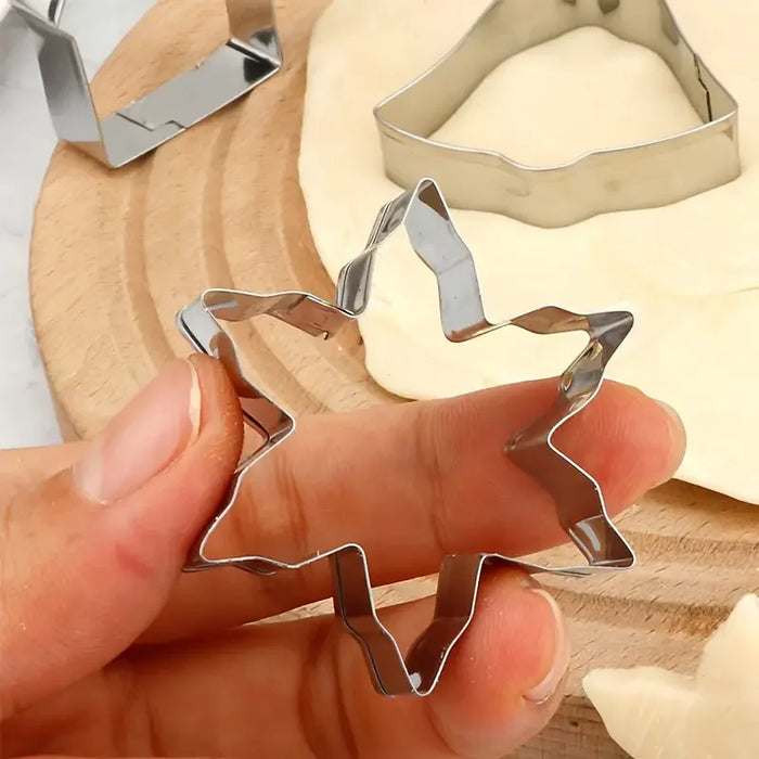 Hand holding a star cookie cutter over dough
