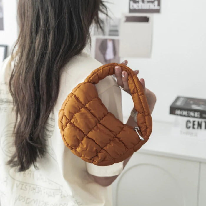 Woman holding a caramel brown mini puffer tote
