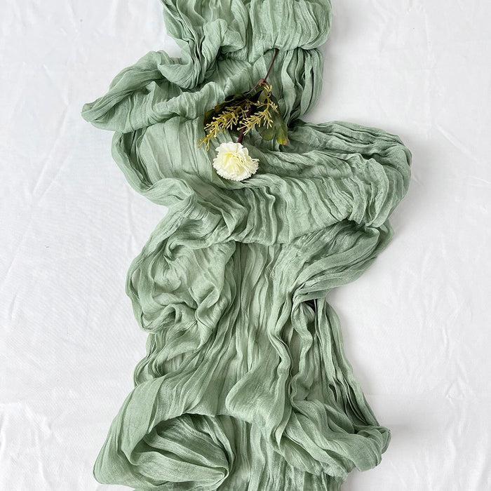 Sage green cheesecloth table runner with flowers