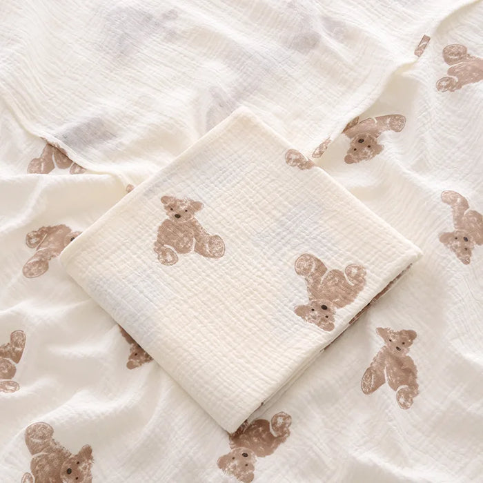 Folded cotton muslin swaddle blanket with teddy bear print