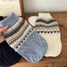 Blue and cream knit dog sweaters held up